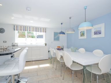 A kitchen with a dining table and chairs at The Cowshed in Portscatho