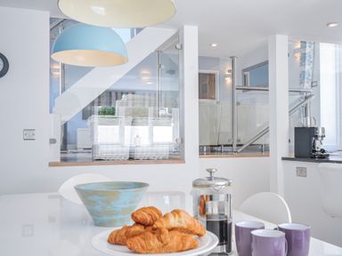 A kitchen with croissants and coffee on the table at The Cowshed in Portscatho