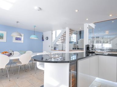 A kitchen with a dining area and countertops at The Cowshed in Portscatho