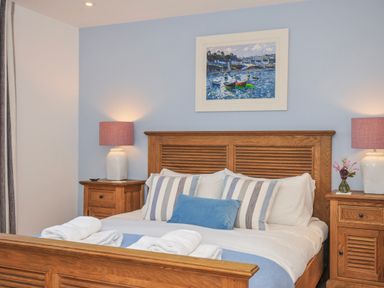 A bedroom with a wooden bed and nightstands at The Cowshed in Portscatho