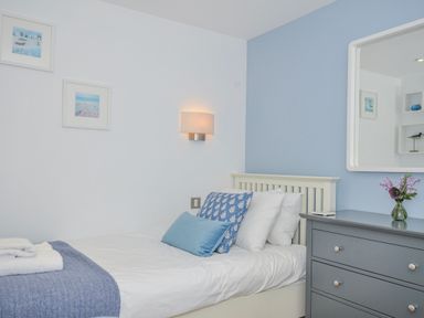 A bedroom with a bed and furniture at The Cowshed in Portscatho