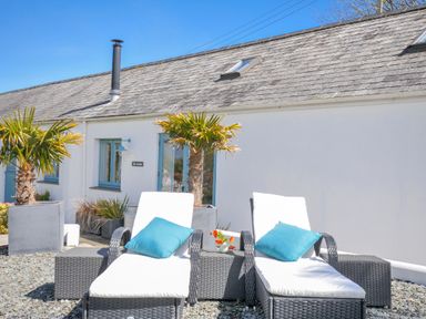An outdoor area with chairs and plants at The Cowshed in Portscatho
