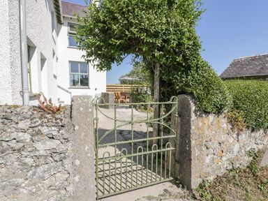 A green gate opening to a pathway at Ty Mawr Farm in Llanfairpwllgwyngyll