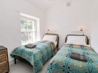 A bedroom with two beds and a window at Ty Mawr Farm in Llanfairpwllgwyngyll