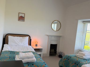 A bedroom with two beds and a mirror at Ty Mawr Farm in Penmynydd near Llanfairpwllgwyngyll