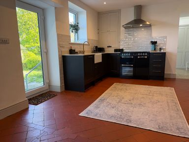 A kitchen with a stove, sink, and cabinets at Ty Mawr Farm in Penmynydd near Llanfairpwllgwyngyll