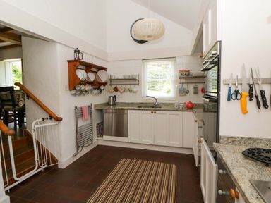 A kitchen with a sink and stove at Cynefin in Newport, Pembrokeshire