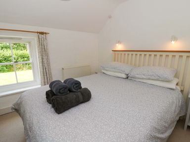 A bedroom with a bed and towels at Cynefin in Newport, Pembrokeshire