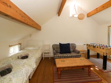 A bedroom with a bed and foosball table at Cynefin Newport, Pembrokeshire