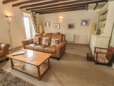 A living room with a sofa and coffee table at Shepherds Nook in Chathill