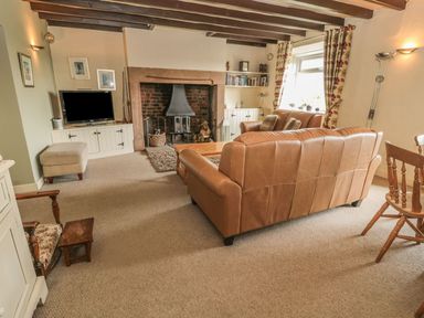 A living room with a sofa and television at Shepherds Nook in Chathill