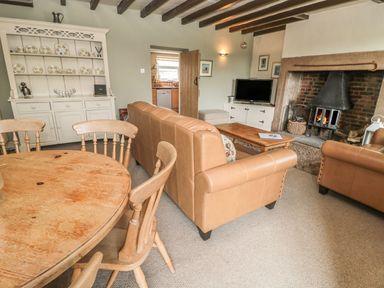 A living room with a sofa and dining table at Shepherds Nook in Chathill