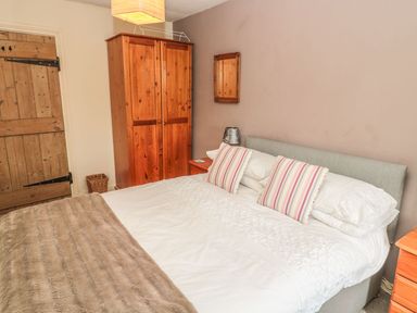 A bedroom with a bed and wardrobe at Shepherds Nook in Chathill