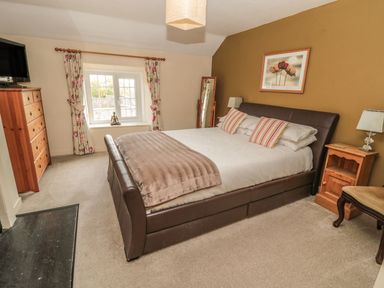 A bedroom with a bed and dresser at Shepherds Nook in Chathill