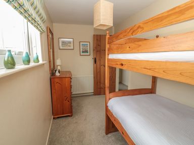 A bedroom with a bunk bed and dresser at Shepherds Nook in Chathill