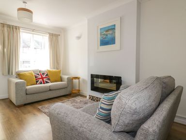 A living room with a sofa and wall art at Seahorses in Padstow