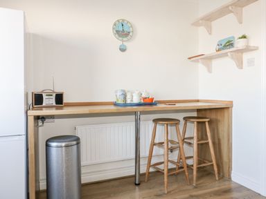 A kitchen with a bar table and stools at Seahorses in Padstow