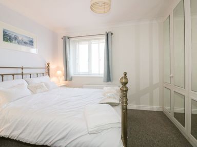 A bedroom with a bed and a wardrobe at Seahorses in Padstow