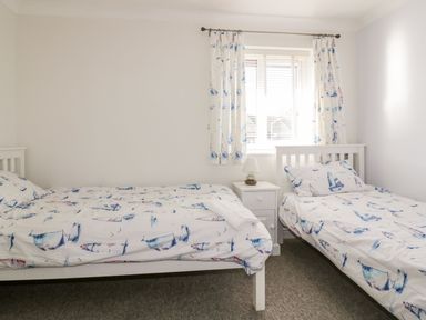 A bedroom with two beds and a bedside table at Seahorses in Padstow