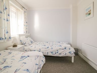 A bedroom with two beds and a bedside table at Seahorses in Padstow