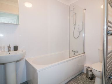 A bathroom with a bathtub, toilet, and sink at Seahorses in Padstow