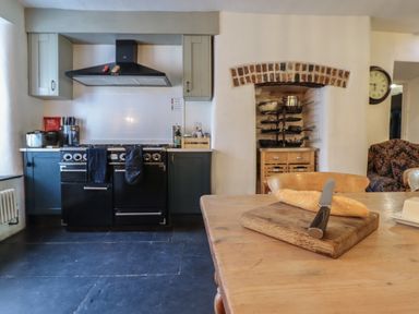 A kitchen with oven, cutting board, and bread at Plas Dolguog in Machynlleth