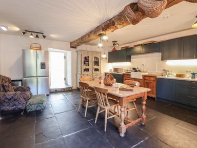 A kitchen with a table and chairs at Plas Dolguog in Machynlleth
