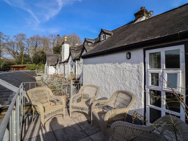 A deck area with chairs at Plas Dolguog in Machynlleth