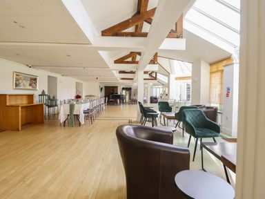 A dining room with tables and chairs at Plas Dolguog in Machynlleth