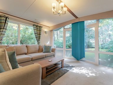 A living room with a sofa and coffee table at Fern View -Kelling Heath Holiday Park in Weybourne near Sheringham