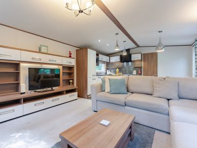 A living room with a television and sofa at Fern View -Kelling Heath Holiday Park in Weybourne near Sheringham