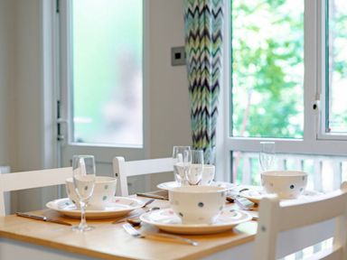 A dining table set with dishes and glasses at Fern View -Kelling Heath Holiday Park Weybourne near Sheringham