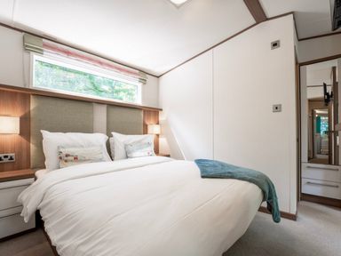 A bedroom with a bed and bedside lamps at Fern View -Kelling Heath Holiday Park, Weybourne near Sheringham