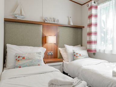 A bedroom with two beds and a lamp at Fern View -Kelling Heath Holiday Park in Weybourne near Sheringham