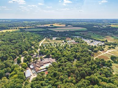 An aerial view of a woodland area with fields and caravans at Fern View -Kelling Heath Holiday Park Weybourne near Sheringham