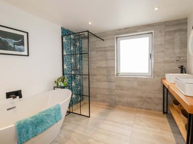 A bathroom with a bathtub, shower, and sink at La Casita in Newquay