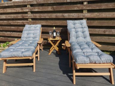 Two deck chairs and a small table with wine and glasses at Carnweather in Newquay
