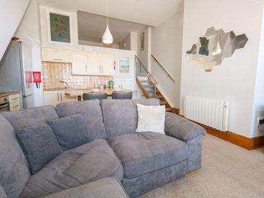 A living room with a sofa and kitchen area at Chandlers Nook in Portland