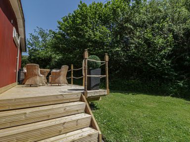 An outdoor deck with chairs and a table at Chalet 23 Erw Porthor in Tywyn