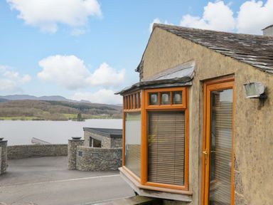 A house with windows overlooking a lake at Wilders Wood in Windermere
