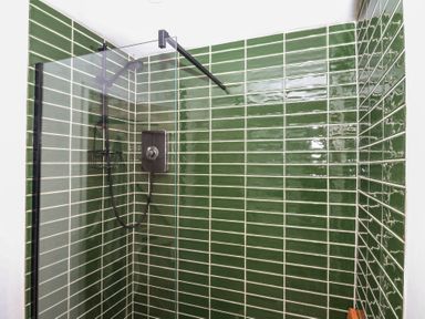 A shower with green tiles at Bedford Cottage in Yelverton