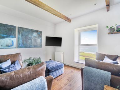 A living room with a television and a window at Cape View near St Just