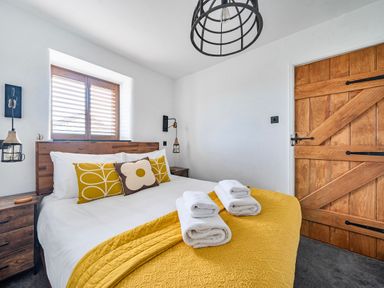 A bedroom with a bed and wooden door at Cape View near St Just