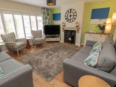 A living room with a sofa, armchairs, and a television at 7 Longstone Close, Chathill