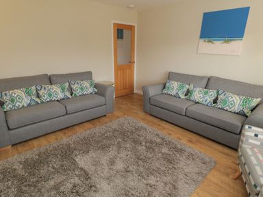 A living room with sofas and a door at 7 Longstone Close Chathill