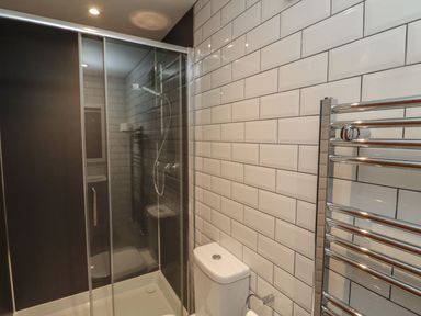 A bathroom with a shower enclosure and toilet at 7 Longstone Close in Chathill