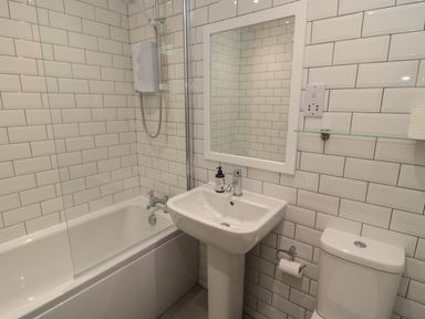 A bathroom with a bathtub, sink, and toilet at 7 Longstone Close Chathill