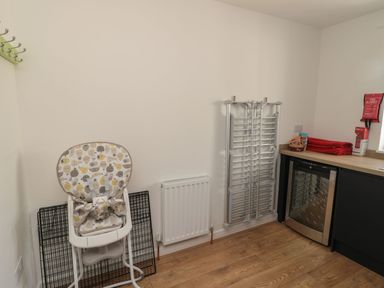 A kitchen with a high chair and wine cooler at 7 Longstone Close Chathill