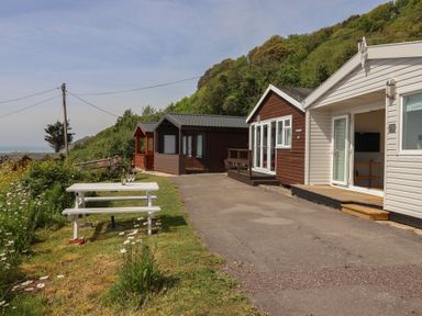 An outdoor area with cottages and a picnic table at Salt & Stone in Lyme Regis