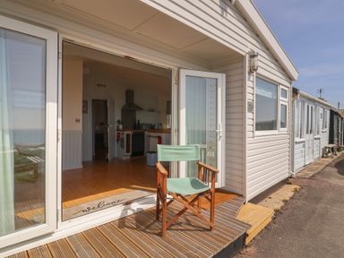An outdoor area with a chair and kitchen view at Salt & Stone in Lyme Regis